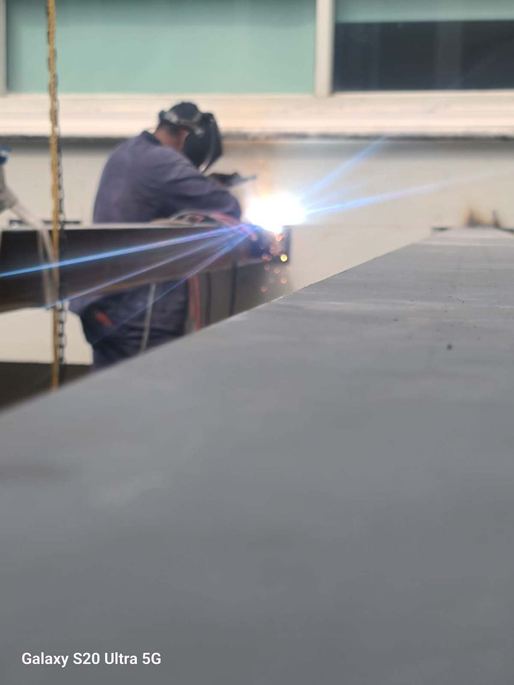 Soldador de GB Iron Solutions trabajando acero estructural en taller